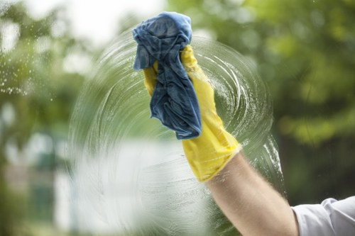 Local cleaner working on glass fronts in Canary Wharf near managed buildings
